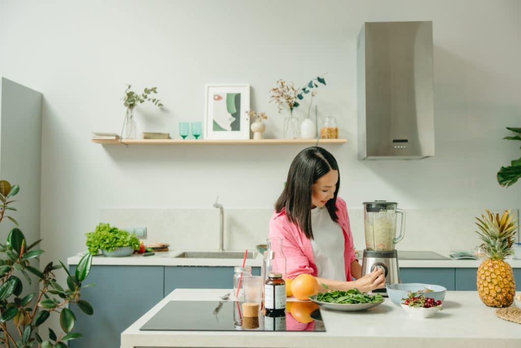 woman cooking in kitchen with meal box subscription